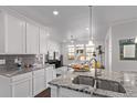 Modern kitchen featuring granite countertops, a stainless steel sink, and views into the adjacent living room at 723 176Th Ave, Broomfield, CO 80023