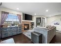 Cozy living room featuring a fireplace, dark hardwood floors, and plenty of natural light at 15800 E 121St Ave # 4K, Brighton, CO 80603