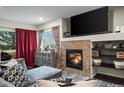 Cozy living room featuring a fireplace, dark hardwood floors, and plenty of natural light at 15800 E 121St Ave # 4K, Brighton, CO 80603