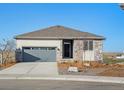 Inviting single-story home with a two-car garage, stone detailing, and well-maintained landscaping at 1967 S Coolidge Way, Aurora, CO 80018