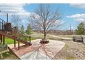 Landscaped backyard with a central tree feature and paved area, ideal for relaxation and gatherings at 20087 E Dartmouth Dr, Aurora, CO 80013