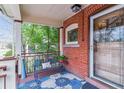Inviting front porch with brick detail, seating, and colorful rug, perfect for relaxing outdoors at 2614 E 13Th Ave, Denver, CO 80206