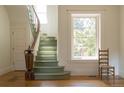 Elegant foyer with curved staircase, diamond-patterned window, and hardwood floors at 3330 Bruce Randolph Ave, Denver, CO 80205