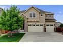 Beautiful two-story home showcasing a manicured lawn and a spacious three-car garage at 2454 Ambience Ln, Castle Rock, CO 80109