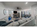 Cozy living room with stone fireplace, mounted TV, ceiling fan, and open access to dining area at 6705 S Field St # 801, Littleton, CO 80128