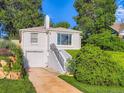 Classic home with landscaped yard, featuring a driveway and stairs leading to the entrance at 2626 N Steele St, Denver, CO 80205