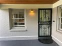 Close-up of the front door featuring a decorative security screen, small window, and gray brick facade at 2626 N Steele St, Denver, CO 80205