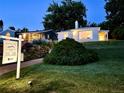 Dusk view of a cozy home with a white brick exterior, nestled in a beautifully landscaped neighborhood, peaceful ambiance at 2626 N Steele St, Denver, CO 80205