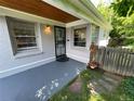 Inviting front porch with gray painted flooring, decorative door, and a view of the surrounding greenery at 2626 N Steele St, Denver, CO 80205