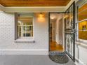 Inviting front porch with open door, showcasing beautiful hardwood floors and stylish interior at 2626 N Steele St, Denver, CO 80205
