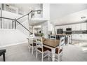 Bright dining room with staircase, island with bar seating, and open to the kitchen at 5797 S Shawnee St, Aurora, CO 80015