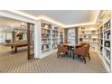 A cozy library features built-in bookshelves, a round table with seating, and is adjacent to the billiards room at 130 N Pearl St # 808, Denver, CO 80203