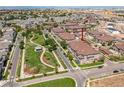 An aerial view shows a well-manicured neighborhood with green spaces and neatly arranged townhomes, near open spaces and mountains at 16700 Las Ramblas Ln # O, Parker, CO 80134