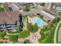 Aerial view showcases a community pool with ample seating, landscaping, fire pit, and nearby parking and residences at 16700 Las Ramblas Ln # O, Parker, CO 80134