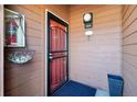 Exterior view of front door with a red steel security door, a light fixture, and the unit number at 540 S Forest St # 3-204, Denver, CO 80246