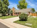 Inviting two-story home with a spacious driveway, lush green lawn, and mature trees providing shade and curb appeal at 6810 S Marion W Cir, Centennial, CO 80122