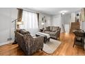 Cozy living room with hardwood floors, comfortable seating, and plenty of natural light filtering through large windows at 6810 S Marion W Cir, Centennial, CO 80122