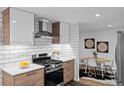 Modern kitchen featuring stainless steel appliances, white subway tile backsplash, and adjacent dining area at 4100 Shaw Blvd, Westminster, CO 80031