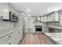Modern kitchen features gray cabinets, stainless steel appliances, and elegant countertops at 10724 E Maplewood Pl, Englewood, CO 80111