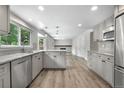 Open kitchen with stainless appliances, island, grey cabinets, and hardwood floors at 10724 E Maplewood Pl, Englewood, CO 80111
