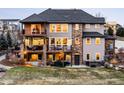 The backyard features a two story patio, hot tub, and stone accents adding charm and providing outdoor enjoyment at 12648 Waterside Ln, Longmont, CO 80504