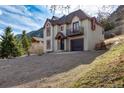 Attractive two-story home featuring cream siding with red trim, situated on a gently sloping, well-maintained lawn at 402 Roosevelt St, Palmer Lake, CO 80133