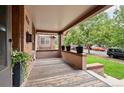 Inviting covered front porch with a wood floor and brick accents, perfect for relaxing outdoors at 1430 Monroe St, Denver, CO 80206