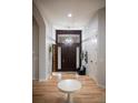 Bright entryway with hardwood floors, a modern chandelier, and a dark wood front door at 226 Hidden Valley Ln, Castle Rock, CO 80108