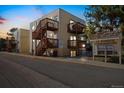 Exterior view of condominiums at dusk featuring private balconies and wooden staircases with 