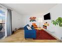 Bright living room features a comfortable blue sofa, stylish decor, and a sliding glass door to a balcony at 9240 W 49Th Ave # 317, Wheat Ridge, CO 80033