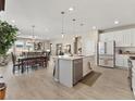 Bright open kitchen featuring a large island, stainless steel appliances, and wood-look floors at 4538 Hidden Gulch Rd, Castle Rock, CO 80104