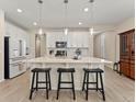 Modern kitchen with white cabinets, stainless steel appliances, and a breakfast bar with three black stools at 4538 Hidden Gulch Rd, Castle Rock, CO 80104