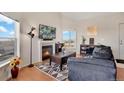 Bright living room with hardwood floors, a cozy fireplace, and plenty of natural light at 2428 W 82Nd Pl # 3A, Westminster, CO 80031