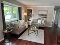Inviting living room featuring a large window, hardwood floors, and neutral decor at 8610 Jolene Dr, Denver, CO 80229