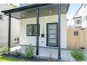 Charming front porch with a stylish door, dark window trim, and manicured landscaping at 1713 Grove St, Denver, CO 80204