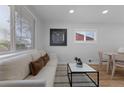 Bright living room with hardwood floors, neutral sofa, and modern decor at 6641 Ash St, Commerce City, CO 80022