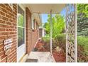 Charming front porch of brick home with decorative metal supports and a welcome sign at 13558 E Center Ave, Aurora, CO 80012