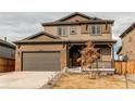 Charming two-story home boasts a large garage, covered front porch, and stylish brown color scheme at 15920 Hayloft Ln, Parker, CO 80134