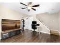 Inviting living room features dark hardwood floors, a ceiling fan and leads to the carpeted stairway and landing at 1607 Cottonwood Dr # 14, Louisville, CO 80027