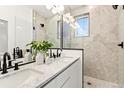 Modern bathroom featuring double vanity, quartz counters, matte black fixtures, and frameless shower at 2142 Applewood Dr, Lakewood, CO 80215