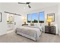 Bright bedroom featuring large window, barn door to bathroom, and stylish bedside tables at 2142 Applewood Dr, Lakewood, CO 80215