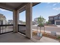 Inviting covered front porch featuring stone columns, black railings and views of the neighborhood at 8585 Eckley St, Littleton, CO 80125