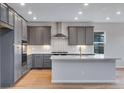 Stylish kitchen with gray cabinets, stainless steel appliances, and quartz countertops at 8585 Eckley St, Littleton, CO 80125