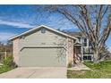 Home with a attached garage, brick accents, and a well-manicured lawn at 9125 W 95Th Ave, Westminster, CO 80021