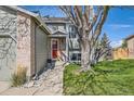 View of a home's covered front entrance with a bright red door and manicured lawn at 9125 W 95Th Ave, Westminster, CO 80021