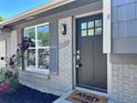 Inviting front entrance with a modern gray door, stylish hardware, and a brick facade at 4382 S Xenon St, Morrison, CO 80465