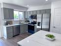 Modern kitchen features gray cabinetry, stainless steel appliances, quartz countertops, and white subway tile at 4382 S Xenon St, Morrison, CO 80465