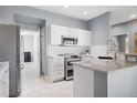 Modern kitchen featuring stainless steel appliances, granite countertops, and white cabinets at 7524 Pineridge Trl, Castle Pines, CO 80108