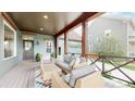 Inviting front porch featuring comfortable seating, wood beams and railings, creating an ideal outdoor relaxation space at 9437 E 51St Dr, Denver, CO 80238
