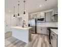 Modern kitchen with a waterfall island, gray cabinets and stainless steel appliances at 27742 E 1St Ave, Aurora, CO 80018